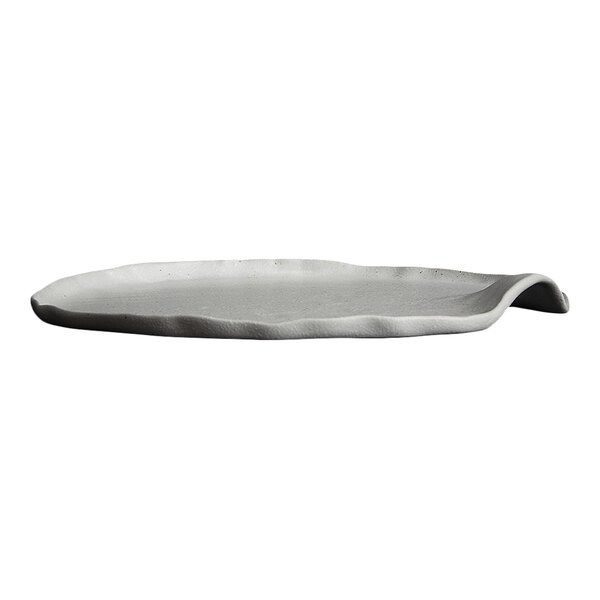 A white, round, stoneware plate with an irregular, organic edge and a slightly raised side.
