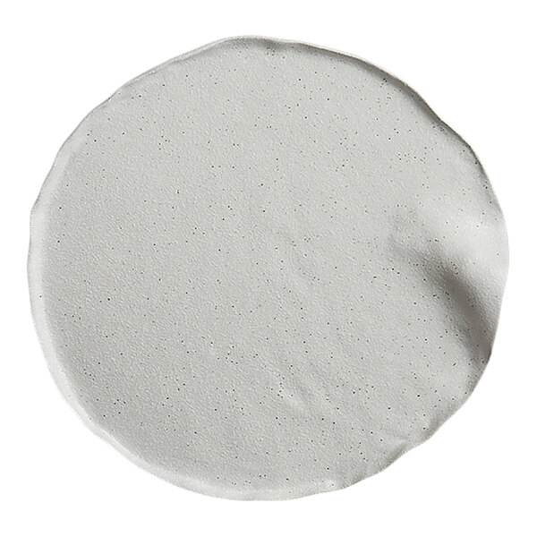 A round, white plate with a slightly irregular edge and a smooth, matte finish.