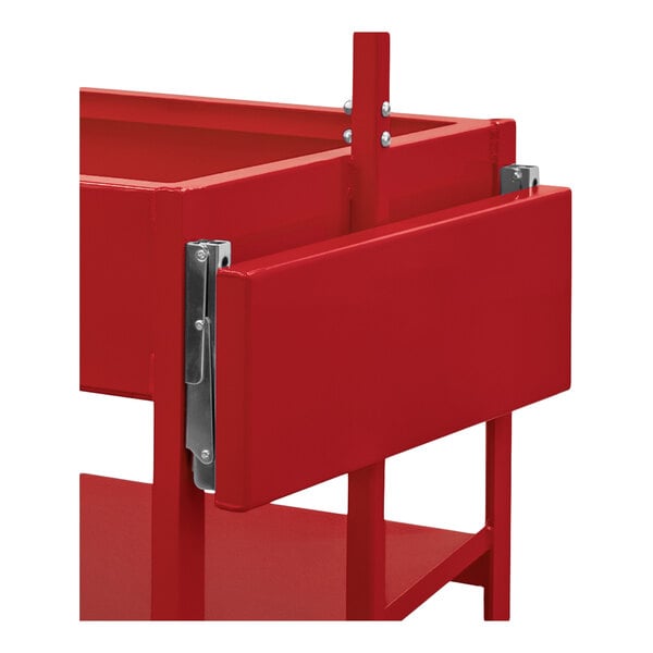A partial view of a red metal structure with a fold-down shelf attached by metal hinges.