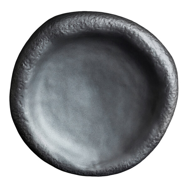 A round, black plate with an irregular, textured rim and a matte finish.