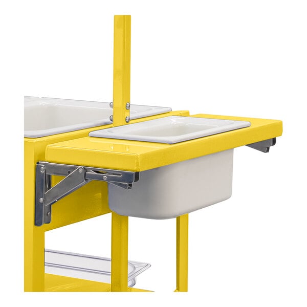 A partial view of a yellow metal cart or shelf with a white rectangular pan inserted into a foldable shelf section.