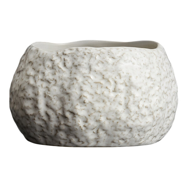 A white, textured bowl with an irregular, organic shape and a rough, stone-like surface.
