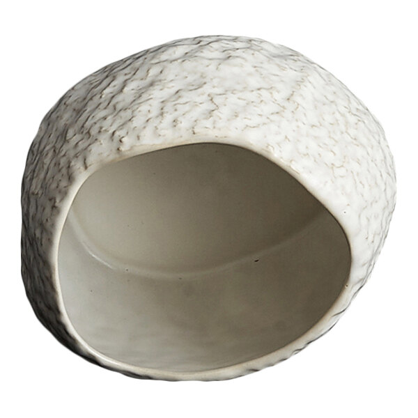 A white, textured, asymmetrical bowl with a wide opening and a rough exterior surface.