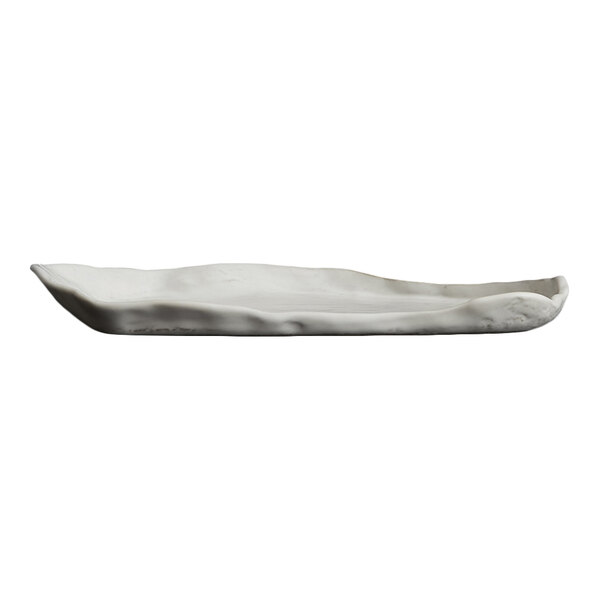 A white, oval-shaped plate with an irregular, organic edge and a smooth surface.