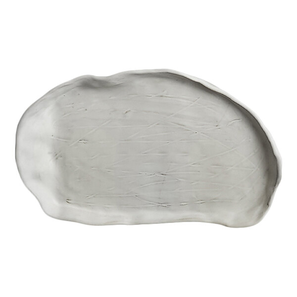 An irregularly shaped, white, oval plate with a slightly raised edge and a textured surface.
