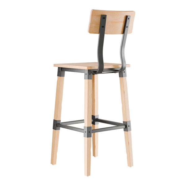 A wooden bar stool with a light bleached oak finish, featuring a square seat, a rectangular backrest supported by two black metal brackets, and black metal supports connecting the legs.