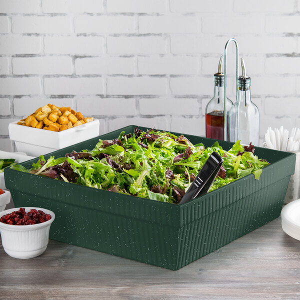 A Tablecraft hunter green rectangular container with white speckles filled with salad on a table.