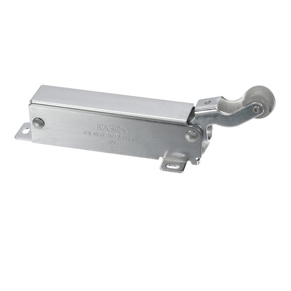 A metallic rectangular device with a hinged arm and a small wheel at one end, likely a door closer mechanism.