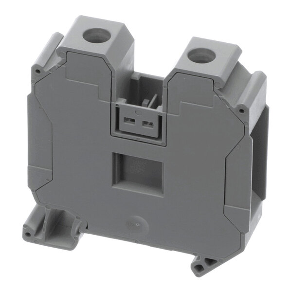 A gray, rectangular plastic component with two circular openings on top and a central rectangular cutout, featuring angular edges and mounting points.