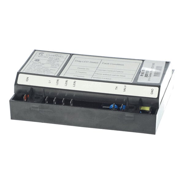 A rectangular black electronic module with labeled connection terminals and a printed instruction label on top.