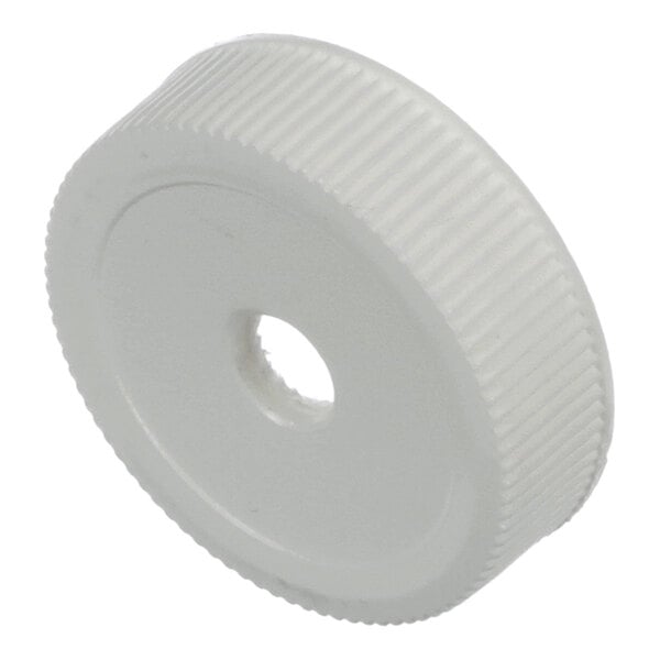 A white, round, ridged plastic cap with a central hole.