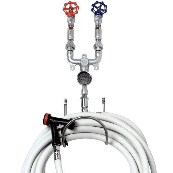 A T&S washdown station with valves, hoses, and a hose rack.