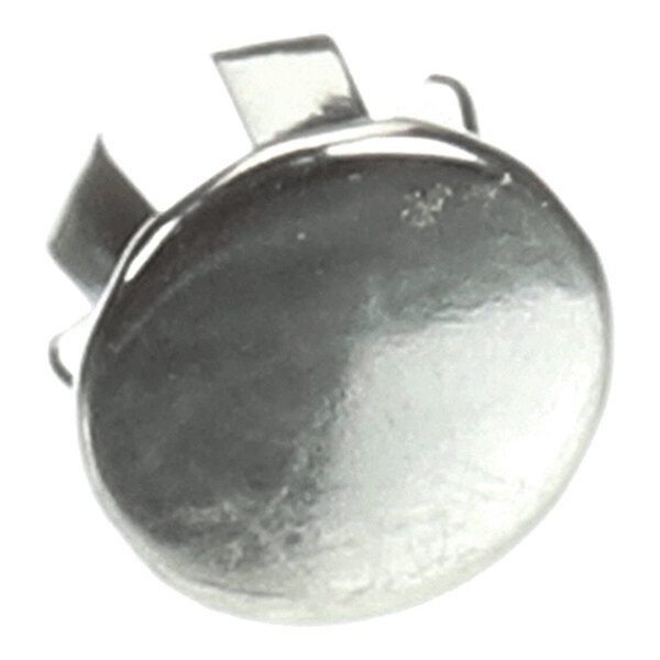 A close-up view of a shiny, metallic, round screw cover with prongs on the back.