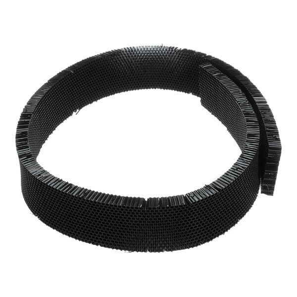 A coiled strip of black honeycomb-patterned material, likely used as an air diffuser.