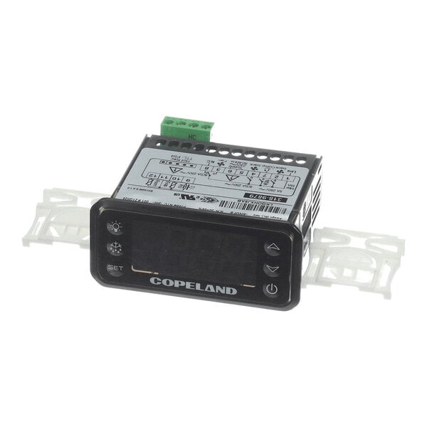 A small electronic control device with a digital display, labeled 'Copeland,' featuring several buttons and a wiring diagram on top.
