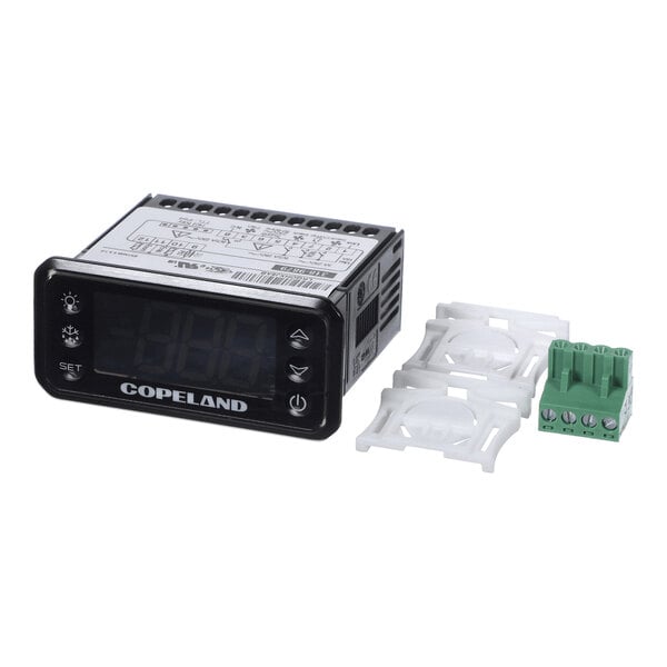 A digital temperature controller with a display screen, labeled 'Copeland,' accompanied by two white mounting brackets and a green terminal block.