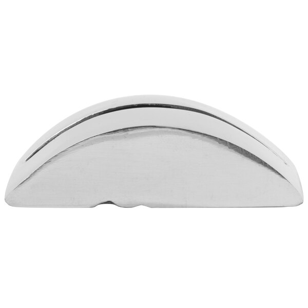 A small, semi-circular, metallic object with a smooth, shiny surface and a single wave-like groove along the top.