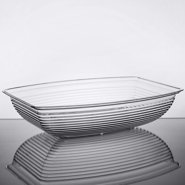 A clear, rectangular bowl with ribbed sides, shown on a reflective surface.