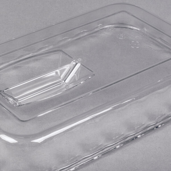 A clear rectangular plastic lid with a raised handle in the center.