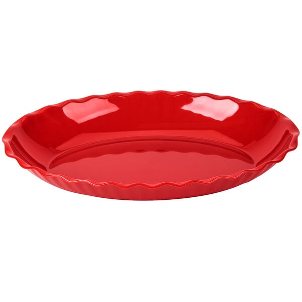 A red, oval-shaped dish with a wavy rim and glossy finish.