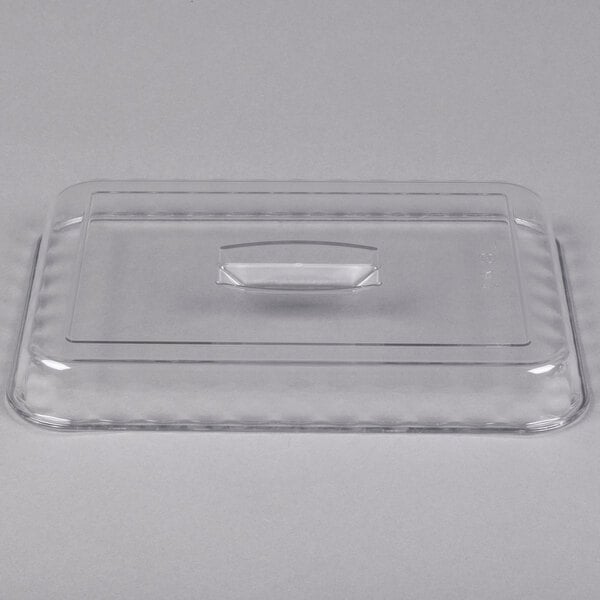 A clear rectangular plastic lid with a central handle, shown resting on a flat surface.