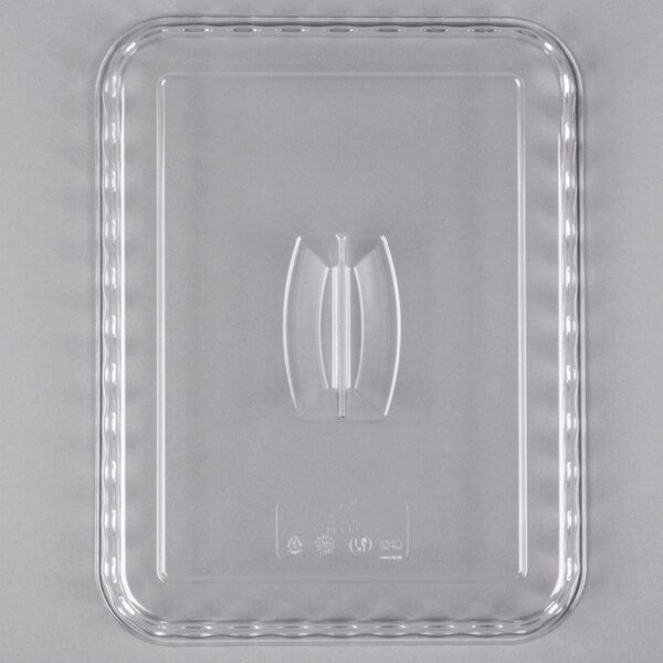 A clear rectangular plastic lid with a central handle, viewed from above.