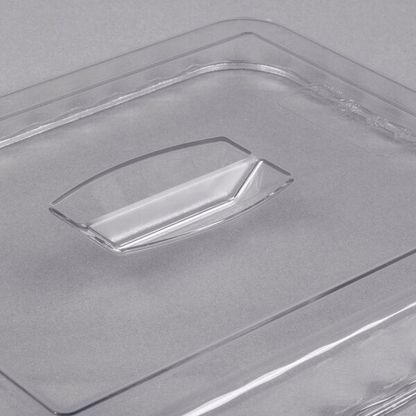 A clear, rectangular plastic lid with a raised handle in the center.
