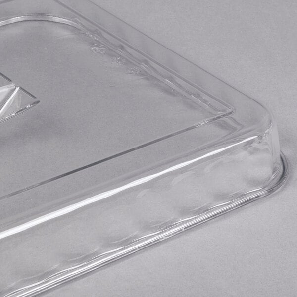 A close-up of a clear, rectangular plastic lid with a raised edge and a handle.