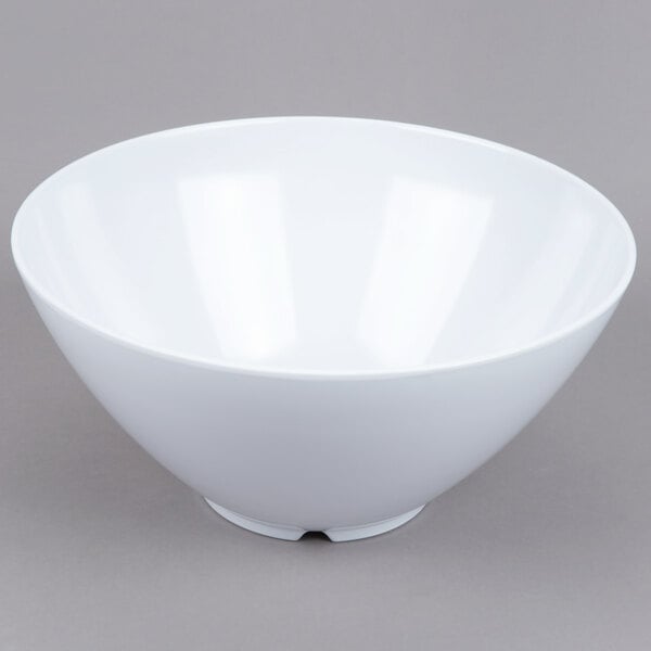 A large, white, round bowl with a smooth surface and a small base, placed on a plain gray background.