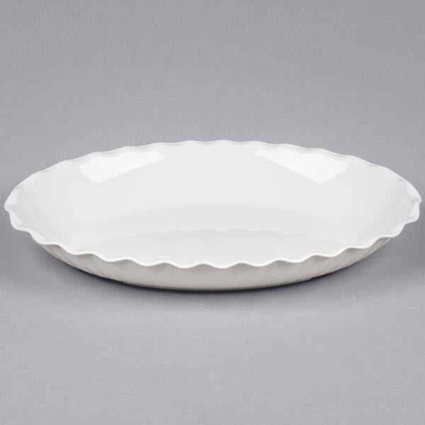 A white, shallow dish with a wavy, scalloped edge, shown against a plain background.