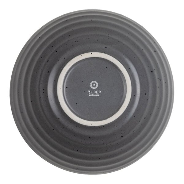 A round, gray bowl with a ribbed texture and speckled pattern, viewed from the bottom, showing a central white ring and the brand name "Ariane."