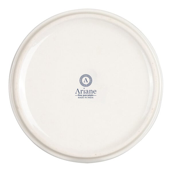 The image shows the bottom view of a round, ivory-colored porcelain dish with the brand name 'Ariane' and 'Made in India' printed in blue at the center.