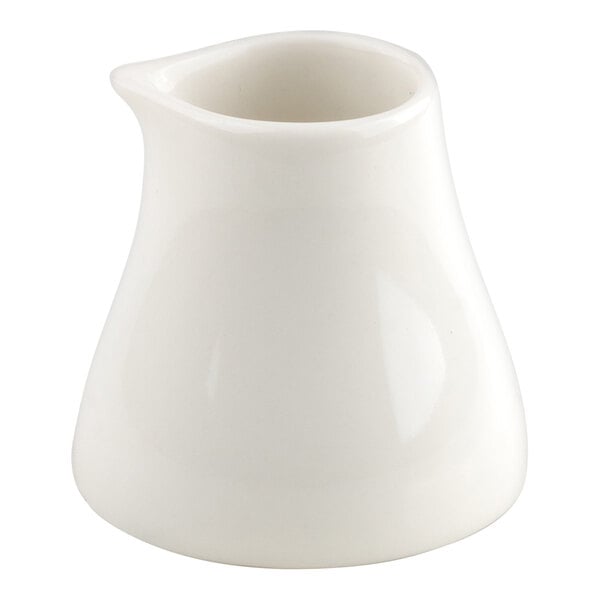 A small, white porcelain creamer with a flared base and a spout.
