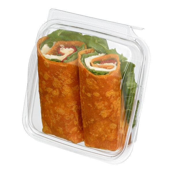Two wrap sandwiches with visible lettuce and other fillings are packaged in a clear, hinged plastic container with a dome lid.