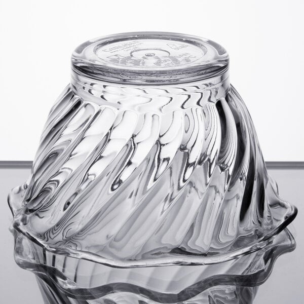 A clear glass bowl with a swirl design on top.