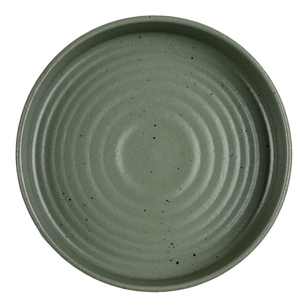 A round, green bowl with a textured, concentric circle pattern and small black speckles.