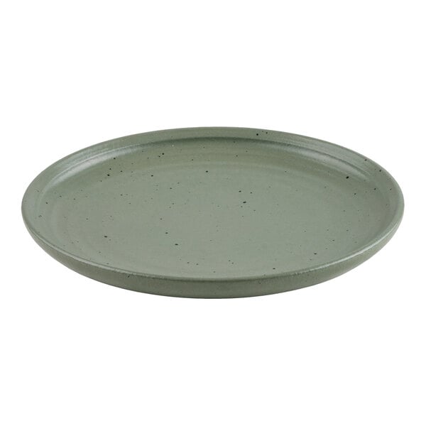 A round, green plate with a slightly raised rim and small black speckles on its surface.