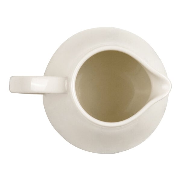 A top-down view of a white ceramic or porcelain creamer with a handle and spout.