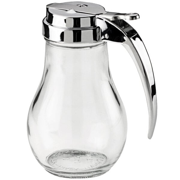A clear glass syrup server with a chrome-plated lid and handle.