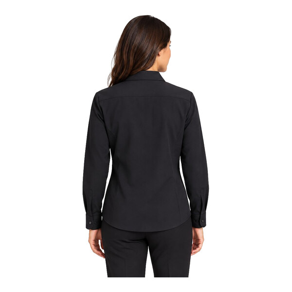 A woman is shown from the back wearing a black long-sleeve collared shirt and black pants.