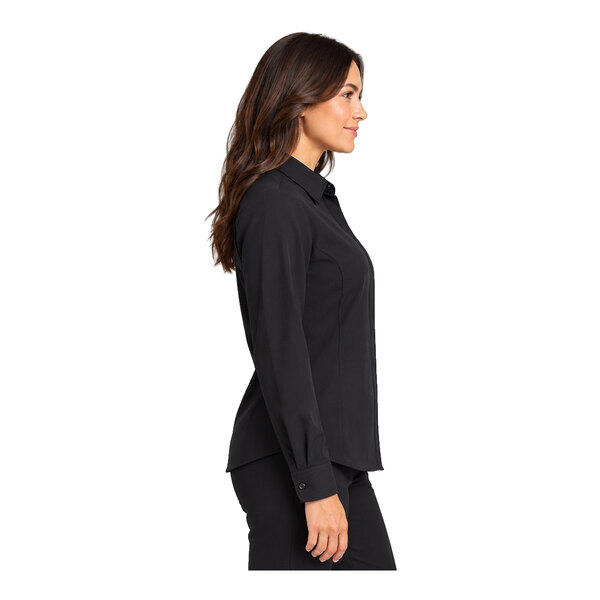 A woman is shown in profile wearing a long-sleeve black button-up shirt and matching black pants.