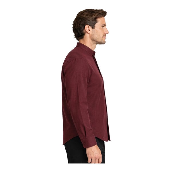 A man is shown in profile wearing a long-sleeve, burgundy button-up shirt with a banded collar and black pants.