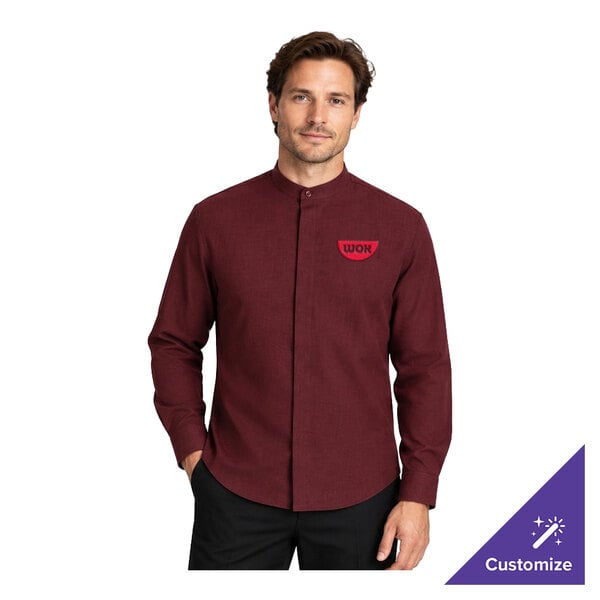 A man is wearing a long-sleeve, burgundy dress shirt with a banded collar and a small red logo on the left chest.