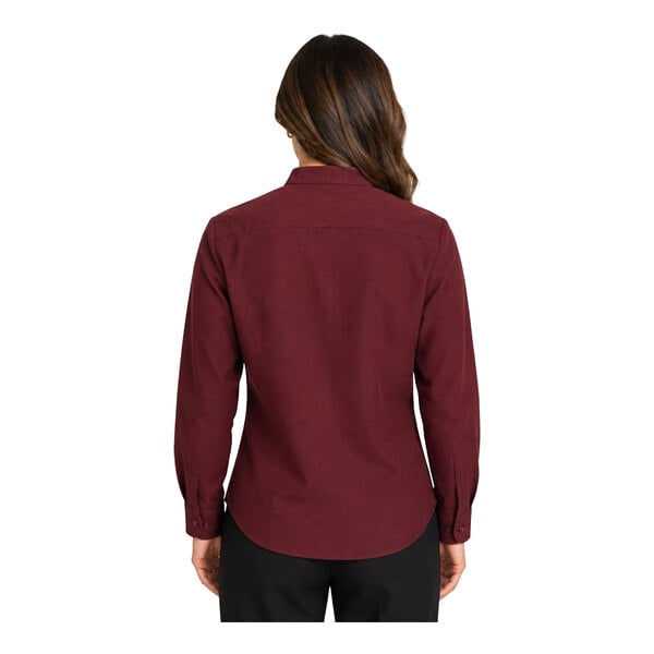A woman is shown from the back wearing a long-sleeve, burgundy button-up shirt and black pants.