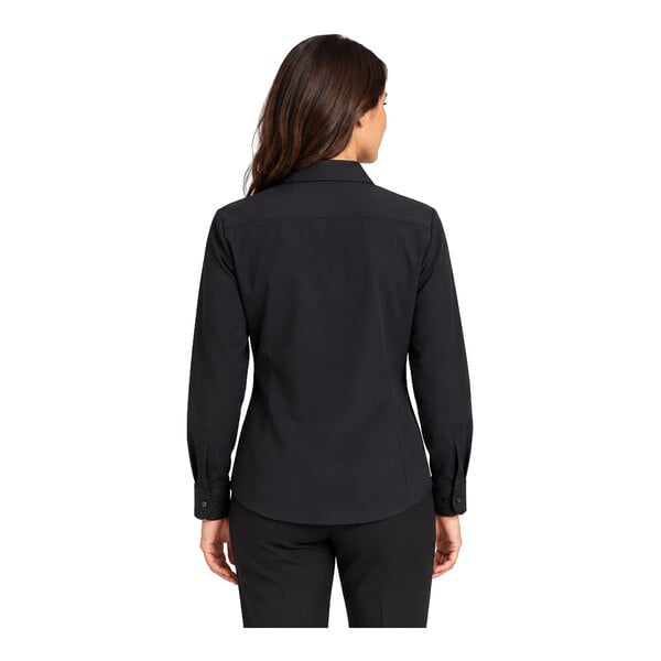 A woman is shown from the back wearing a long-sleeve black shirt and black pants.