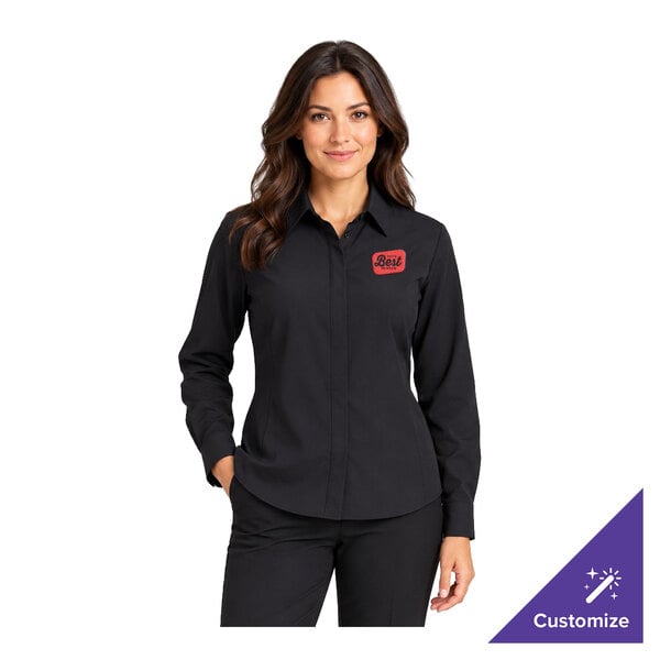 A woman is wearing a black long-sleeve button-up shirt with a red embroidered name patch on the left chest.