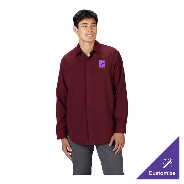 A man is wearing a long-sleeve burgundy dress shirt with a collar and gray pants, featuring a small purple logo on the left chest.