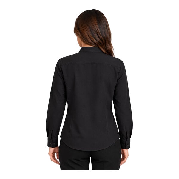 A woman is shown from the back wearing a long-sleeve black shirt and black pants.