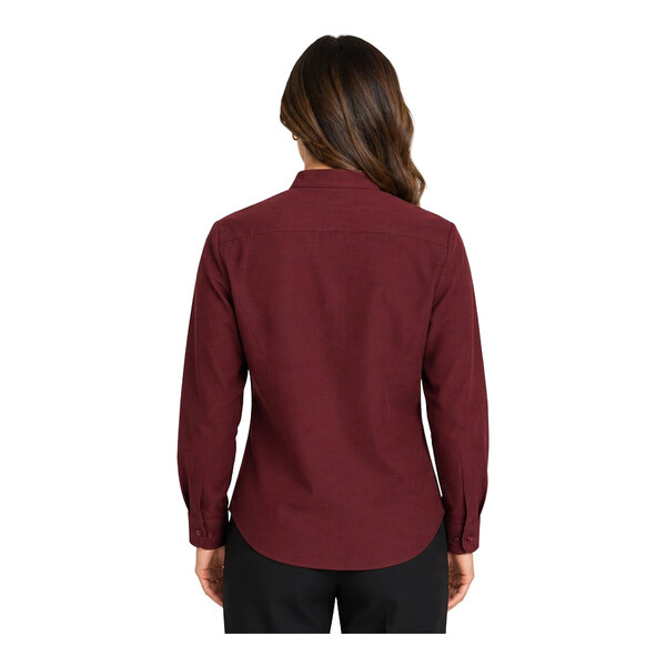 A woman is shown from the back wearing a long-sleeve, burgundy button-up shirt and black pants.