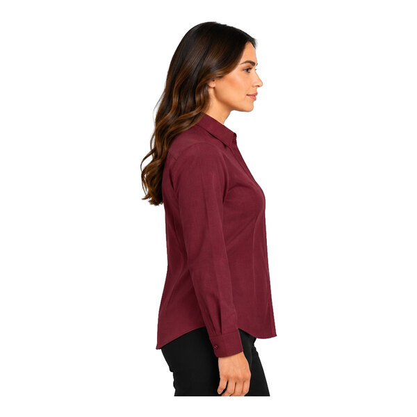 A woman is shown in profile wearing a long-sleeve, burgundy button-up shirt and black pants against a white background.